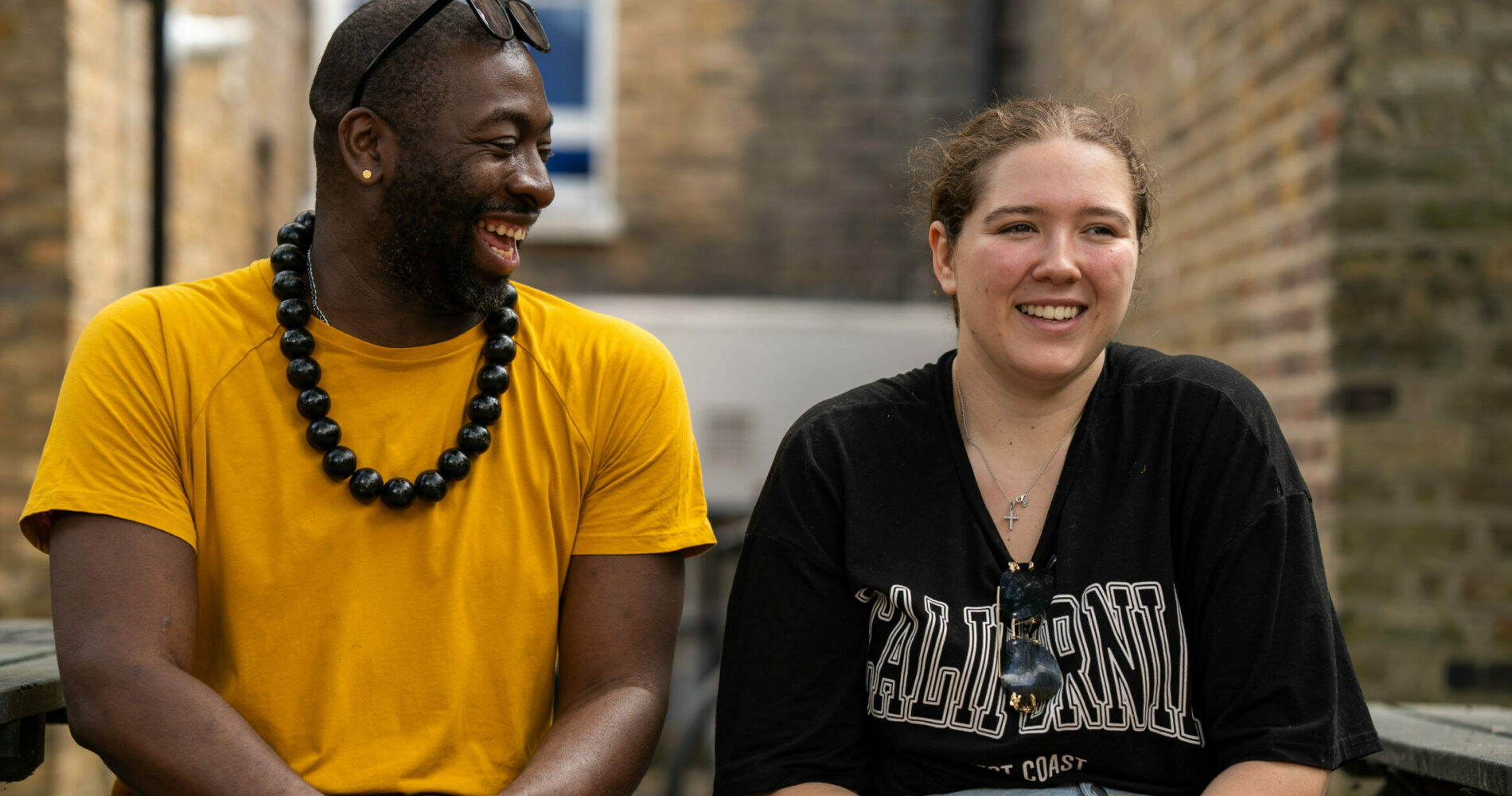 The front cover of Look Ahead's impact report showing a happy young person and support worker laughing together.